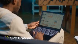 Homem com notebook apoiado sobre as pernas analisando um sistema com gráficos semelhante ao Radar de Riscos da SPC Grafeno